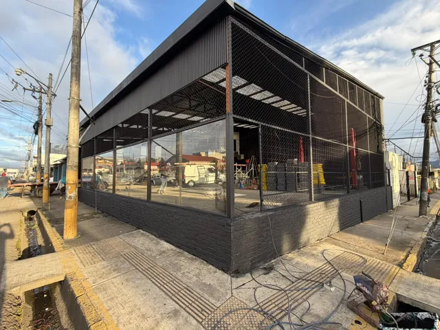 Fachada de un edificio con estructura negra y cerramiento de vidrio
