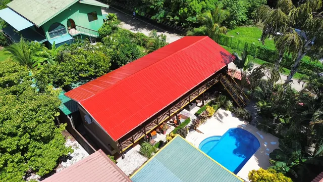 Vista aérea de cubiertas rojas de un complejo de hospedaje con piscina