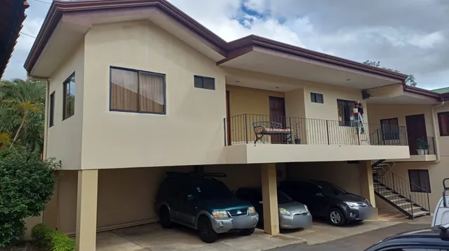 Condominio residencial de dos niveles con fachada pintada en beige