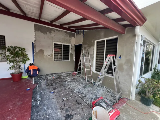 Corredor con paredes en proceso de repello y empaste