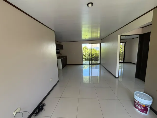 Sala con paredes blancas y piso brillante, terminada